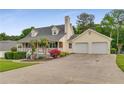 Charming home featuring a brick and siding exterior, a covered front porch, an attached two-car garage, and a paved driveway at 1320 Pinyon Pl, Lawrenceville, GA 30043