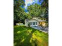 Charming two-story home featuring lush green lawn, classic black shutters, and lovely trees surrounding the property at 287 Willow Cove Ct, Lawrenceville, GA 30044