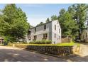 Rear view of a home with a stone retaining wall, landscaping, and easy access to street at 3158 Granby Ave, Scottdale, GA 30079
