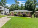 Brick home with a green lawn, complimented by mature trees and a convenient concrete driveway at 1315 Merry Ne Ln, Atlanta, GA 30329