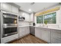 Bright kitchen boasts modern gray cabinetry, stainless appliances, and stylish hardwood floors at 1315 Merry Ne Ln, Atlanta, GA 30329