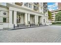 Luxury condo entrance featuring large white pillars, a covered entry, and detailed stonework at 195 14Th Ne St # 303, Atlanta, GA 30309