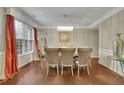 Elegant dining room featuring a modern chandelier, large windows, and hardwood floors at 202 Roseman Way, Woodstock, GA 30188