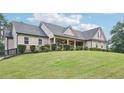 Beautiful home with a stone and siding exterior and a neatly kept lawn at 2118 Braswell Ln, Loganville, GA 30052