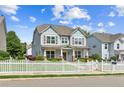 Inviting two-story home featuring a white picket fence, manicured landscaping, and covered front porch at 3725 Downing Dr, Cumming, GA 30040