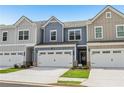 Attractive exterior view of townhomes showcasing garages, colorful sidings, and lovely lawns at 1181 Chastain Dr, Sugar Hill, GA 30518