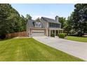 Beautifully landscaped home with a two-car garage, charming front porch, and a well-maintained lawn at 305 Hickory Pointe Ct, Villa Rica, GA 30180