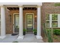 Up-close front entrance featuring stately columns and olive-painted doors at 531 Headwind Way, Alpharetta, GA 30005