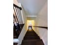 Elegant staircase with dark wood steps, white walls, and a view towards a sunlit door at 3235 Chutney Ct, Avondale Estates, GA 30002