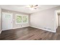 Bright living room with hardwood floors, a ceiling fan, a window, and a white door at 4009 Kirksford Dr, Decatur, GA 30035