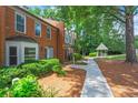 Serene community featuring brick townhomes, lush greenery, and a charming gazebo, creating a tranquil atmosphere at 4113 Ashford Green Dr, Duluth, GA 30096