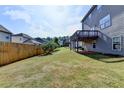 Large grassy backyard with a wooden fence and a view of the home's rear deck at 4250 Pembia Dr, Cumming, GA 30028