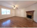 Bright living room featuring hardwood floors, a ceiling fan, and a charming stone fireplace at 294 Spring Leaf Dr, Dallas, GA 30157