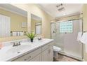 Bright bathroom featuring double sinks, a glass shower and a decorative fern at 440 Barrington W Dr, Roswell, GA 30076