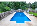 Full, wide view of a large, rectangular swimming pool surrounded by a wooden fence at 879 Old Tucker Rd, Stone Mountain, GA 30087