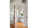 Bright foyer with hardwood floors, modern lighting, and a round mirror accenting the entryway at 1392 Cornwall Rd, Decatur, GA 30032