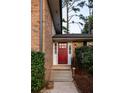 Charming red front door with sidelights and concrete steps leading to a well-maintained brick facade at 1392 Cornwall Rd, Decatur, GA 30032
