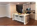Kitchen island with bar stool seating, stainless steel appliances, and open access to living area at 1783 Shetley Creek Drive, Norcross, GA 30071