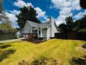 Expansive backyard featuring a well-maintained lawn and mature trees under a blue sky with white clouds at 208 Arbour Way, Suwanee, GA 30024