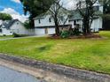 Charming home featuring a two-car garage, stone accents, and a well-maintained front yard at 208 Arbour Way, Suwanee, GA 30024