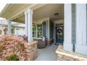 Inviting front porch featuring stone accents, a seating area, and a decorative wreath on the door at 214 Misty View Dr, Canton, GA 30114