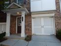 Townhome exterior showcasing brick facade, covered porch, and garage at 2199 Landing Walk Dr, Duluth, GA 30097