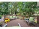 Relaxing wooden deck with seating, colorful flowers, and views of the tree-filled backyard at 3609 Meadow Chase Dr, Marietta, GA 30062