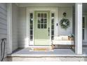This home's entrance has a light green door, wreath, and a bench with cushions and pillows at 361 Princeton Way, Lawrenceville, GA 30044