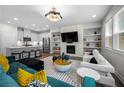 Modern living room featuring a fireplace with a TV, and a kitchen in the background at 774 Belrose Dr, Smyrna, GA 30080