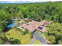 Aerial view of property featuring an in-ground pool, tennis court, multiple outbuildings and lush landscaping at 1572 Azalea Dr, Lawrenceville, GA 30043