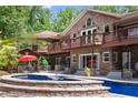 Beautiful backyard featuring a pool with stone trim, a covered patio, a gazebo, and mature landscaping at 1572 Azalea Dr, Lawrenceville, GA 30043