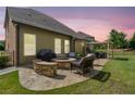 Back patio with stone fire pit, wicker furniture, grill and outdoor dining area at 3015 Arbor Song Ct, Cumming, GA 30041