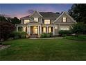 Beautiful home at dusk featuring a manicured lawn and welcoming covered front porch at 32 Pullman Trl, Acworth, GA 30101