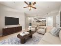 Well-lit living room featuring a ceiling fan, and an open floor plan leading into the kitchen area at 390 17Th Nw St # 2005, Atlanta, GA 30363