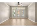 Bright and airy living room featuring French doors, fresh paint, and beautiful light wood floors at 390 17Th Nw St # 2005, Atlanta, GA 30363