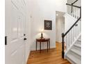 Bright foyer with hardwood floors, white trim, a coat closet and a staircase with black banisters at 1117 Haven Glen Ne Ln, Brookhaven, GA 30319