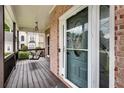 Inviting covered front porch includes wood flooring and a comfortable porch swing at 1226 Kelly Nelson Ct, Lawrenceville, GA 30043