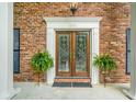 Elegant front door with intricate glass detailing, complemented by brick and white trim at 1691 Houghton N Ct, Atlanta, GA 30338