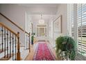 Bright entryway features hardwood floors, elegant staircase, and wainscoting, leading to a glass-paneled front door at 3401 Village Green Dr, Roswell, GA 30075