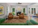 Cozy living room with fireplace, hardwood floors, shuttered windows, and comfortable seating with natural light at 3401 Village Green Dr, Roswell, GA 30075