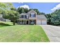 Charming two-story home with a manicured lawn, inviting front porch, and two-car garage at 5385 Spotted Fawn Ct, Suwanee, GA 30024