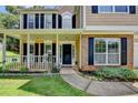 Inviting front porch with white railing, lush landscaping, and brick accents at 5385 Spotted Fawn Ct, Suwanee, GA 30024