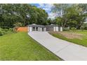 Inviting home with a concrete driveway, well-manicured lawn, and a beautifully landscaped yard at 1272 Sherwood Dr, Norcross, GA 30093