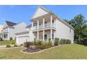 A charming two-story home with a manicured lawn and a welcoming front porch at 129 Academy Ln, Canton, GA 30114