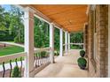 Spacious front porch features stately columns, decorative railings, and a stained wood ceiling at 332 Mount Zion Rd, Oxford, GA 30054