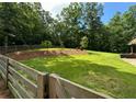 Expansive backyard with lush lawn, mature trees, and rustic wooden fence at 241 Wooten Ct, Canton, GA 30114