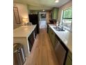 Modern kitchen featuring stainless steel appliances, sleek countertops, and stylish green cabinetry at 241 Wooten Ct, Canton, GA 30114