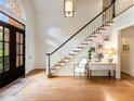 Inviting foyer with hardwood floors, a staircase, and a large arched window above the black double-door entry at 350 Fountain Oaks Ln, Atlanta, GA 30342