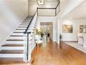 Bright foyer features hardwood floors, high ceilings, an elegant staircase, and an open view to the living area at 350 Fountain Oaks Ln, Atlanta, GA 30342
