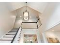 Elegant staircase with a black handrail and white spindles, ascending to a second-story landing with a light fixture at 350 Fountain Oaks Ln, Atlanta, GA 30342